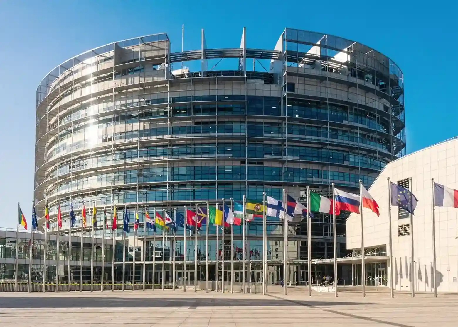 EU-Parlament mit Haverkamp Shielding dunkel 16 RS sr silber Abhörschutzfolie auf Glasfassade hinter Flaggenmasten.