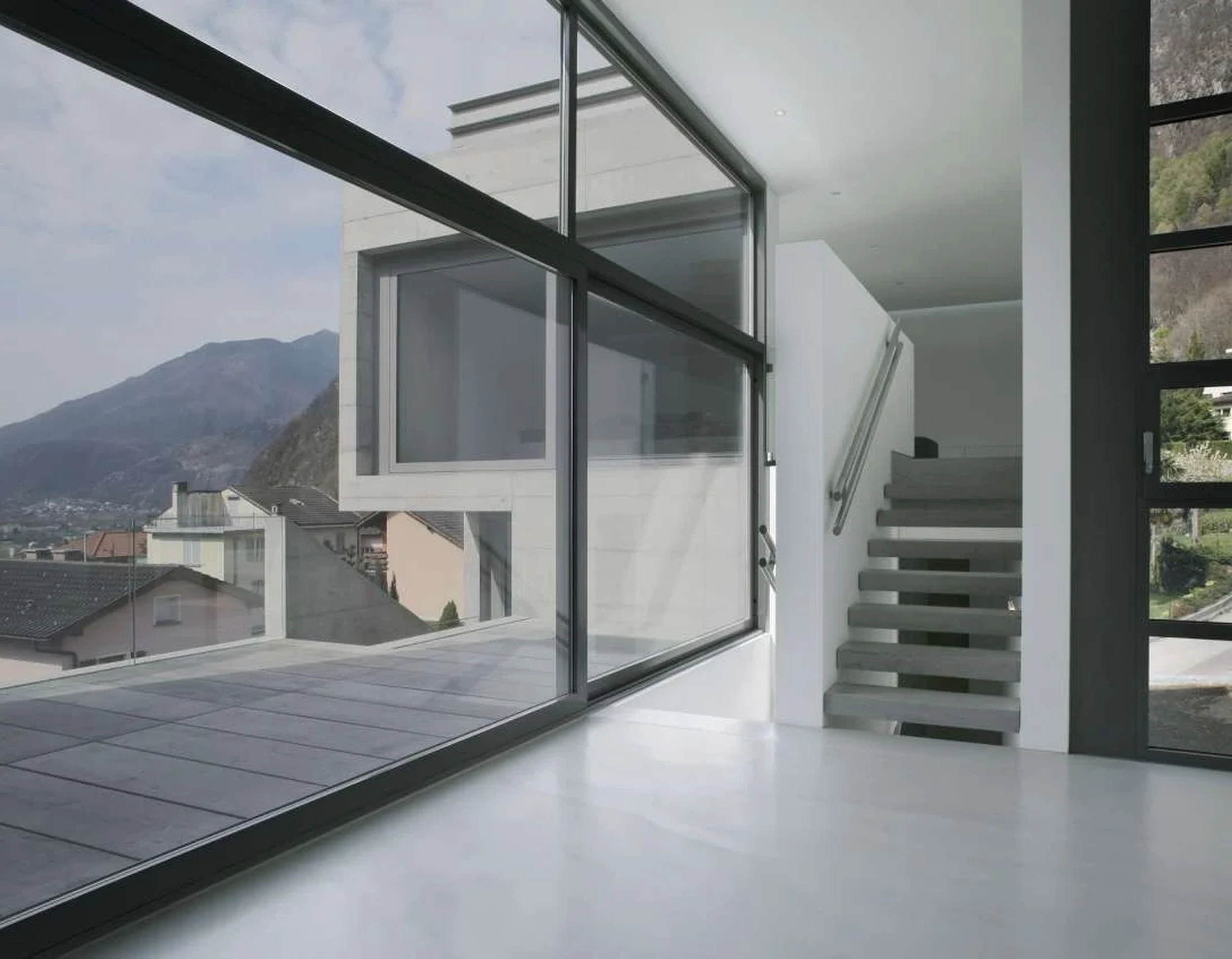 Haverkamp Sonnenschutzfolie Silber 20R SR an den großen Fenstern eines Hauses in den Bergen.