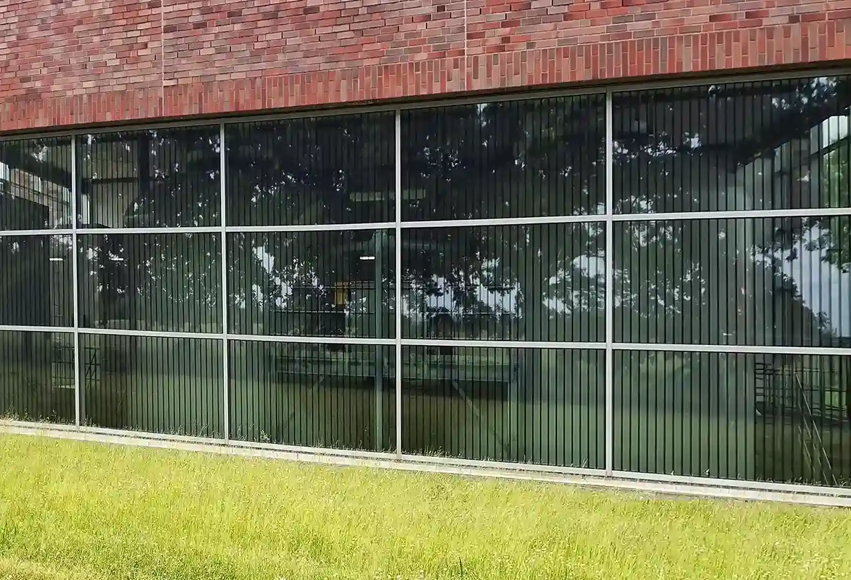 Glasfront eines Backsteingebäudes geschützt mit Haverkamp birdsafe® Vogelschutzfolie Punktraster schwarz schwarz.