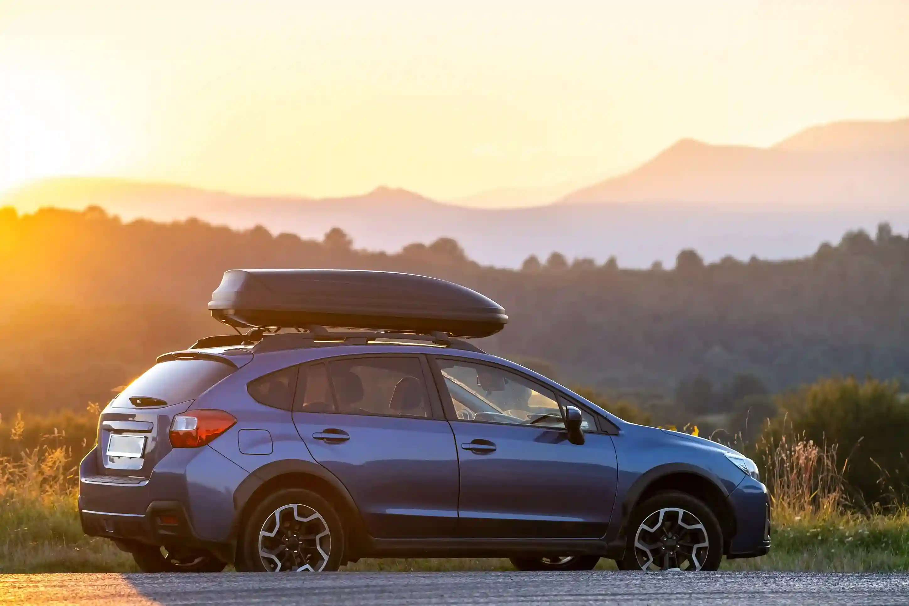 SUV mit Dachbox bei Sonnenuntergang; hintere Scheiben sind getönt mit HAVERKAMP Best Bond 12.