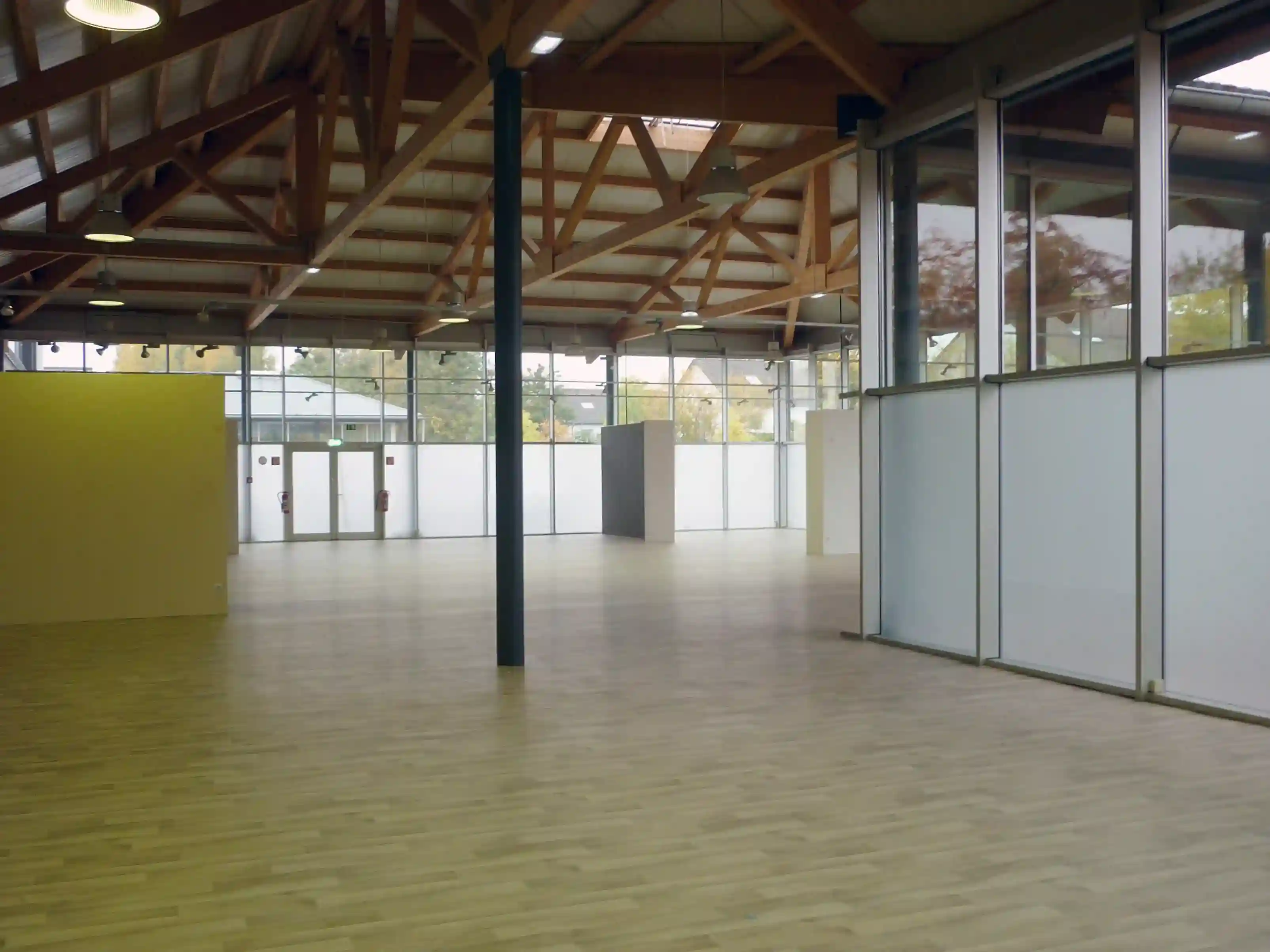 Große, leere Halle mit Holzdachkonstruktion und Glasfronten foliert mit Haverkamp Weiß Undurchsichtig.