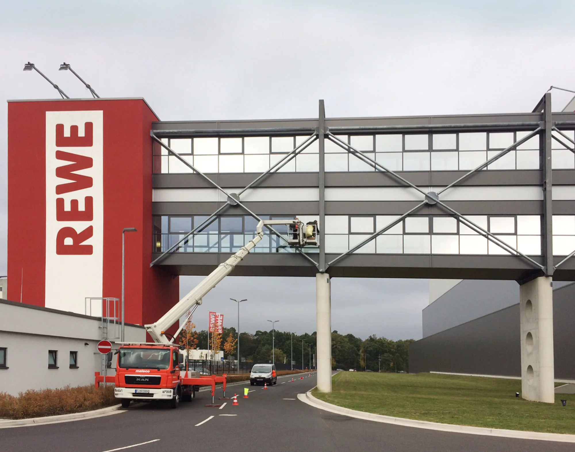 Analysiert Montage von Haverkamp Silber Dunkel 20R SR Primus Plus Sonnenschutzfolie auf einer REWE-Verbindungsbrücke.